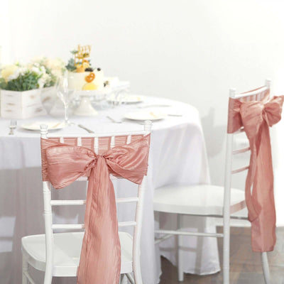 Elegant pink chair sashes on white wedding chairs at a beautifully set table.