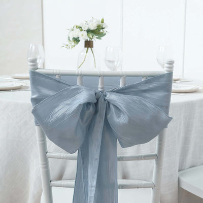 Light blue satin chair sash with a large bow on a white chair.