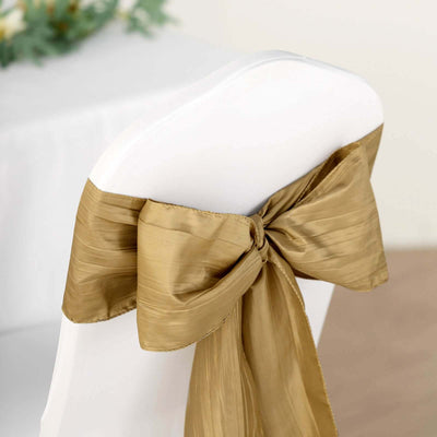 Gold satin chair sash tied in a bow on a white chair.
