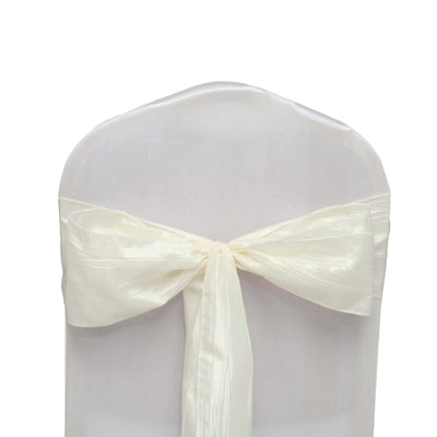 White chair cover with satin ribbon bow, elegant event decoration.