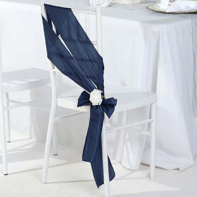 Navy chair sash with white flower decoration on a white chair