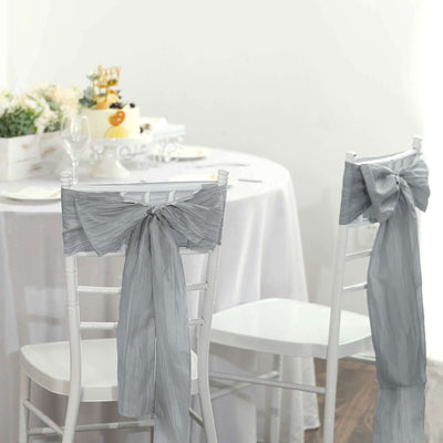 Elegant gray chair sashes with bows for wedding or event decor.