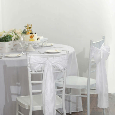 Elegant white chair sashes at a festive dining setup.