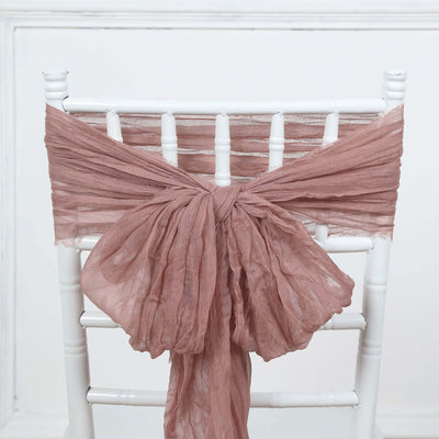 Dusty rose chiffon chair sash tied on a white chair.