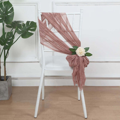 Chair decorated with mauve draping and a floral accent.