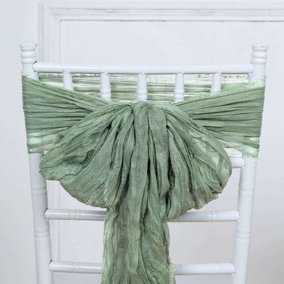 Green linen chair tie draped elegantly on a white chiavari chair.