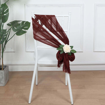 Burgundy chair sash with rose accent on a white chair