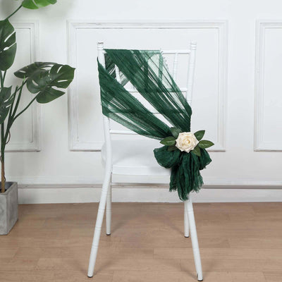 Green chiffon chair sash with white rose and leaves decoration.