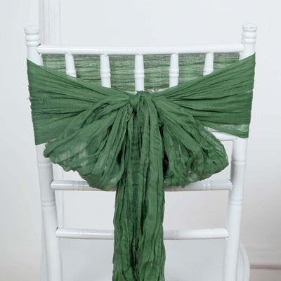 Green chair sash tied in a decorative bow on a white chair.