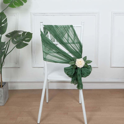 Green chiffon chair wrap with a white rose accent on a white chair.