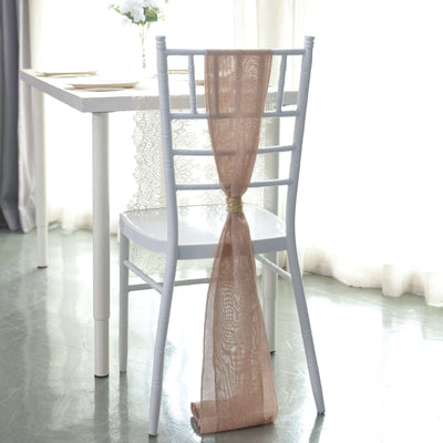 White chair with beige ribbon draped on the back, styled for an elegant setting.