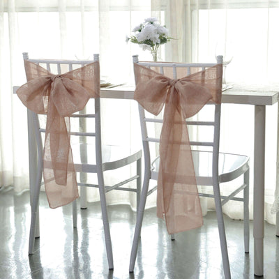 Elegant chair sashes in soft beige tied in bows for event decor.