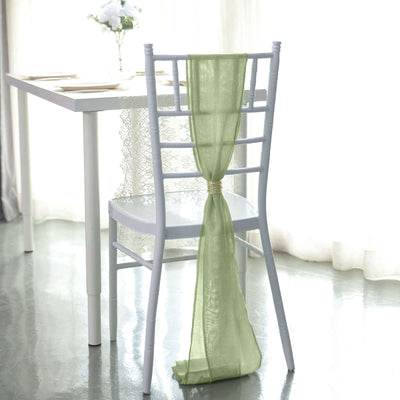Green chair tie draped elegantly on a white chair in a bright dining setting.