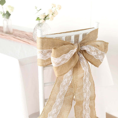 Burlap chair bow with lace detailing on a white chair in a decorated setting.