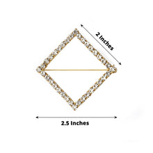 A Gold Diamond Shaped Rhinestone Encrusted Sash Pin with measurements of 2.5 inches and 2 inches