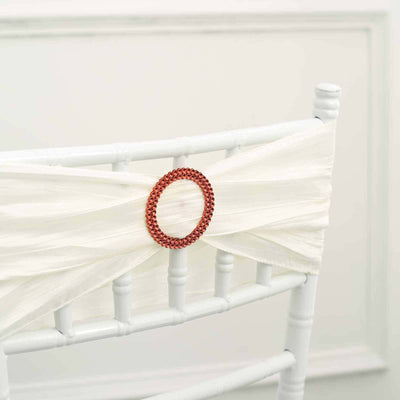 Red beaded chair sash buckle on a white chair cover
