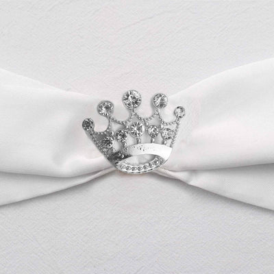 Silver crown brooch on white fabric ribbon
