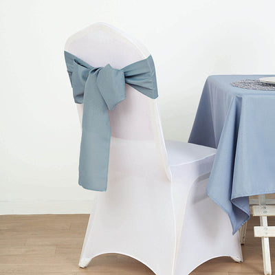Blue chair cover with bow on a white chair in a styled setting.