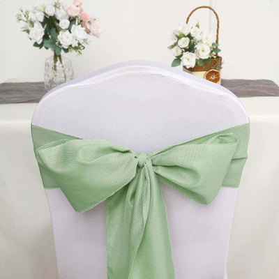 Green satin chair sash tied in a bow on a white chair.