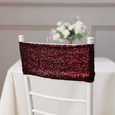 Red sequin chair cover on a white chair at an elegant table setting.