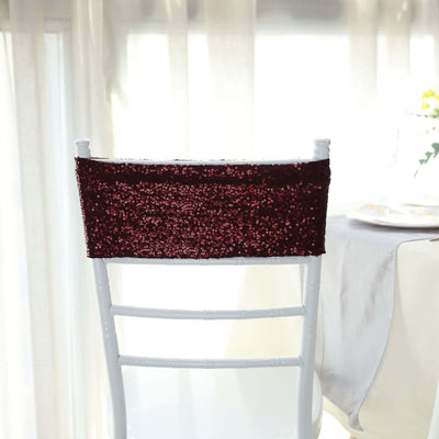 Burgundy sequin chair cover on a white chair in a bright setting.
