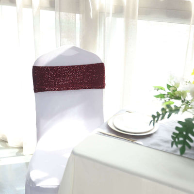 Elegant white chair with burgundy sequin sash, set for an intimate dining experience.