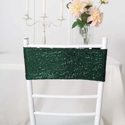 Green sequin chair sash on a white chair in a decorated setting.