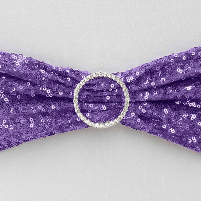 Purple sequin bow with a rhinestone ring center on a neutral backdrop.