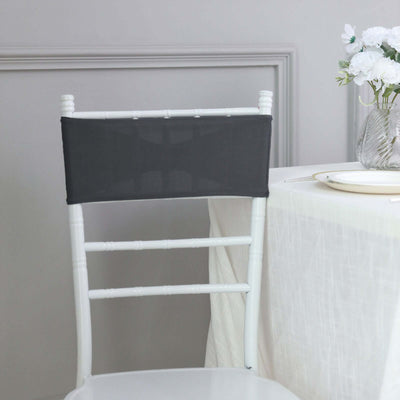 Gray chair cover on a white chiavari chair at a dining table.