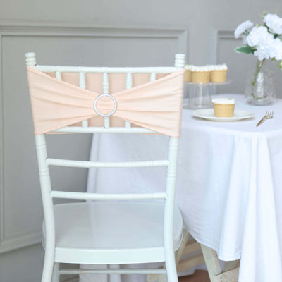 Peach chair sash with rhinestone detail on a white chair in a decorated setting.