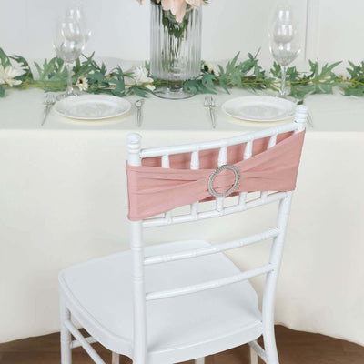 Pink chair sash with decorative buckle on a white chair in a dining setting.