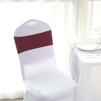 White chair with a burgundy sash at a dining table.
