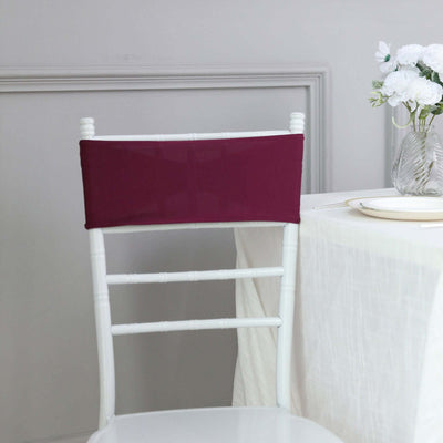 Burgundy chair cover on a white chiavari chair in a dining setting.