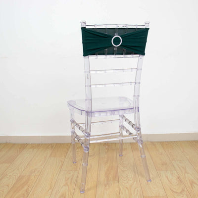 Clear acrylic chair with a green fabric sash on the back.