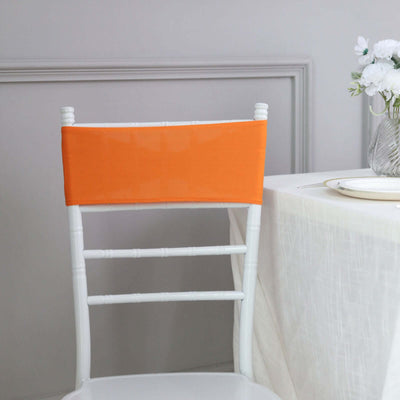 Orange chair back cover on a white chiavari chair in a dining setting.