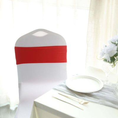 White chair with red sash by a table setting in a bright, elegant dining space.