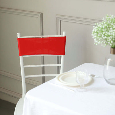 Red chair back cover on a white dining chair in a stylish setting.