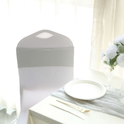 Elegant white chair cover with gray sash in bright dining setting.