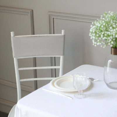 Elegant white dining chair with soft gray backrest against a minimalistic setting.