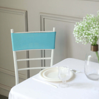 Turquoise chair cover on a white chair in a dining setup.