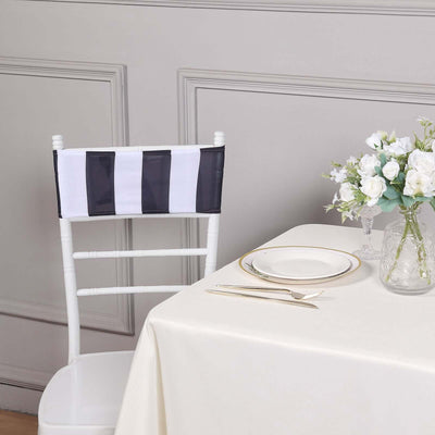 Black and white striped chair cover on a white chair beside a dining table.