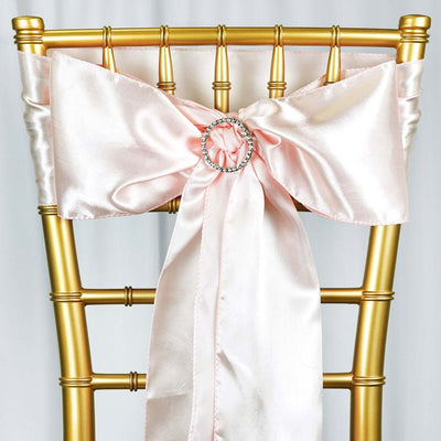 Gold chiavari chair with a pink satin sash and rhinestone buckle.