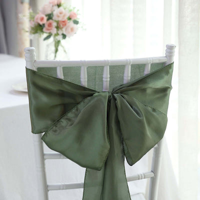 Green satin chair sash with a large bow, perfect for event decor.