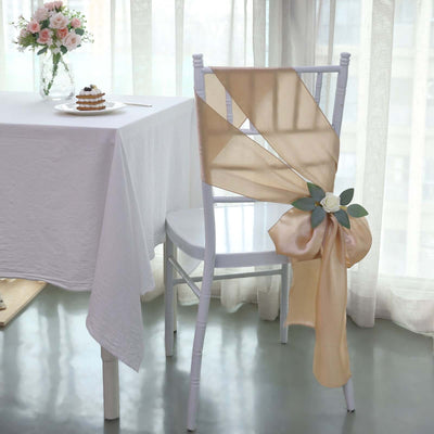 Elegant gold chair sash with flower decoration in a stylish dining setting.