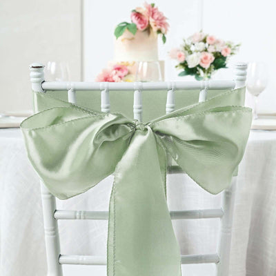 Satin chair bow in soft green, elegantly tied on a white chair.