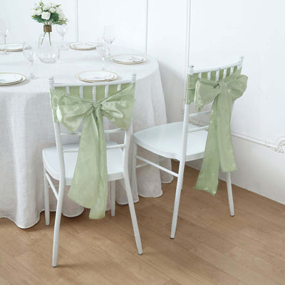 White chairs with green bows at a beautifully set dining table.
