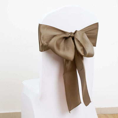 Brown satin chair bow with a large bow design on a white chair.