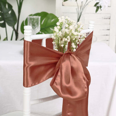 Decorative chair sash with silk ribbon and flowers in a styled setting.