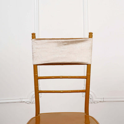 Gold chiavari chair with a cream satin ribbon on the back.