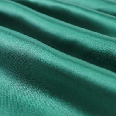 Close-up of smooth green fabric with rich texture and folds.